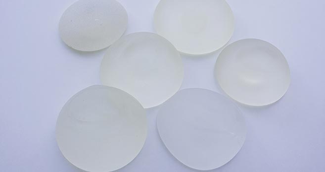 A variety of breast implant options sit on a table. A variety of breast implant options sit on a table.