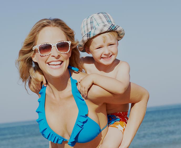 After her mommy makeover, a mom plays with her young son at the beach.