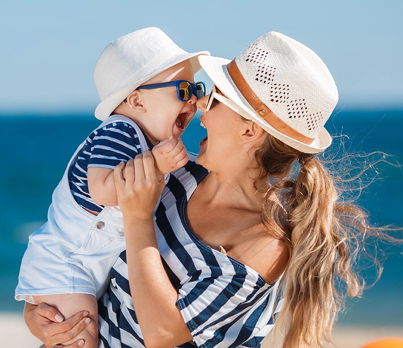 woman-on-beach-laughing-with-baby